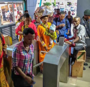 women and men move through dar es salaam brt- DART- station turnstyle