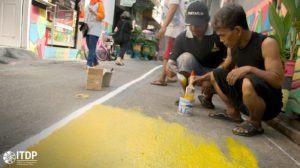 men painting streets in Sunter Jaya urban village in Jakarta, Indonesia