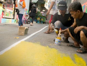 men painting streets in Sunter Jaya urban village in Jakarta, Indonesia