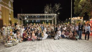 Large group of people smiling with traditional Brazilian dancers